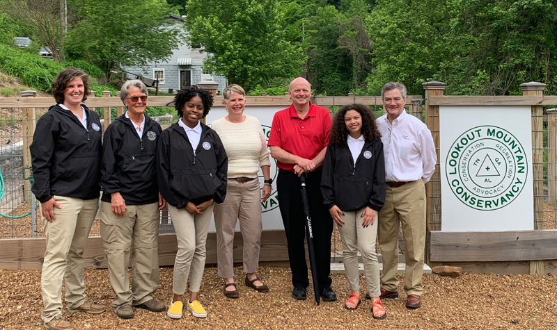 Interns stand with staff from LMC, Ruby Falls, Rock City, and Coca Cola in front of the vegetable garden