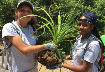 Hayle and Imani holding a Daylilie that they are about to transplant