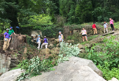 Interns and youth works clearing a wall