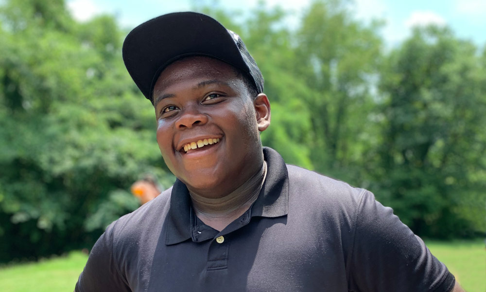 Head shot of JaMaal - LMC Intern Young Black male with black hat on smiling at the camera