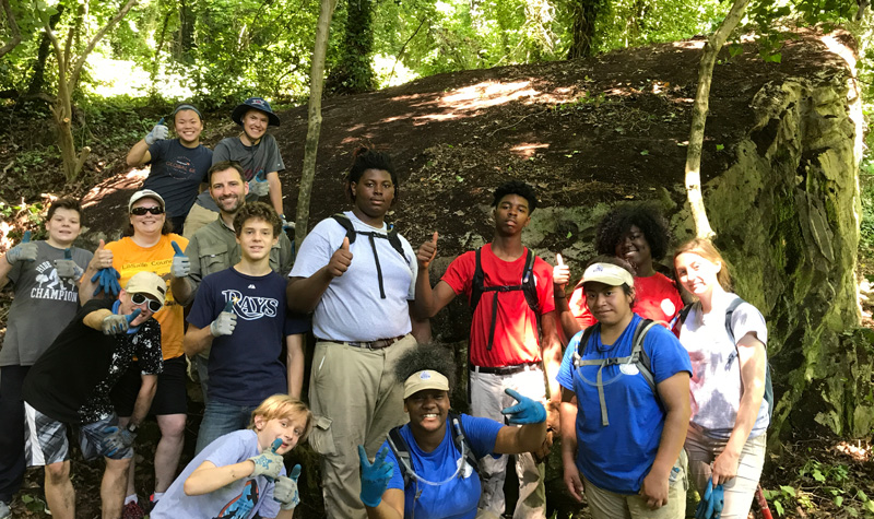 Interns and youth works after clearing off a boulder