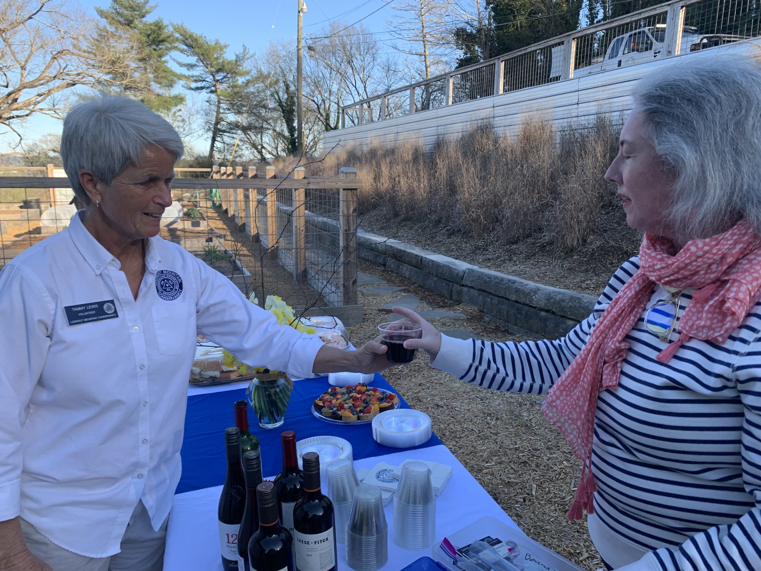 Tammy serving board member Mary Anne a glass of wine