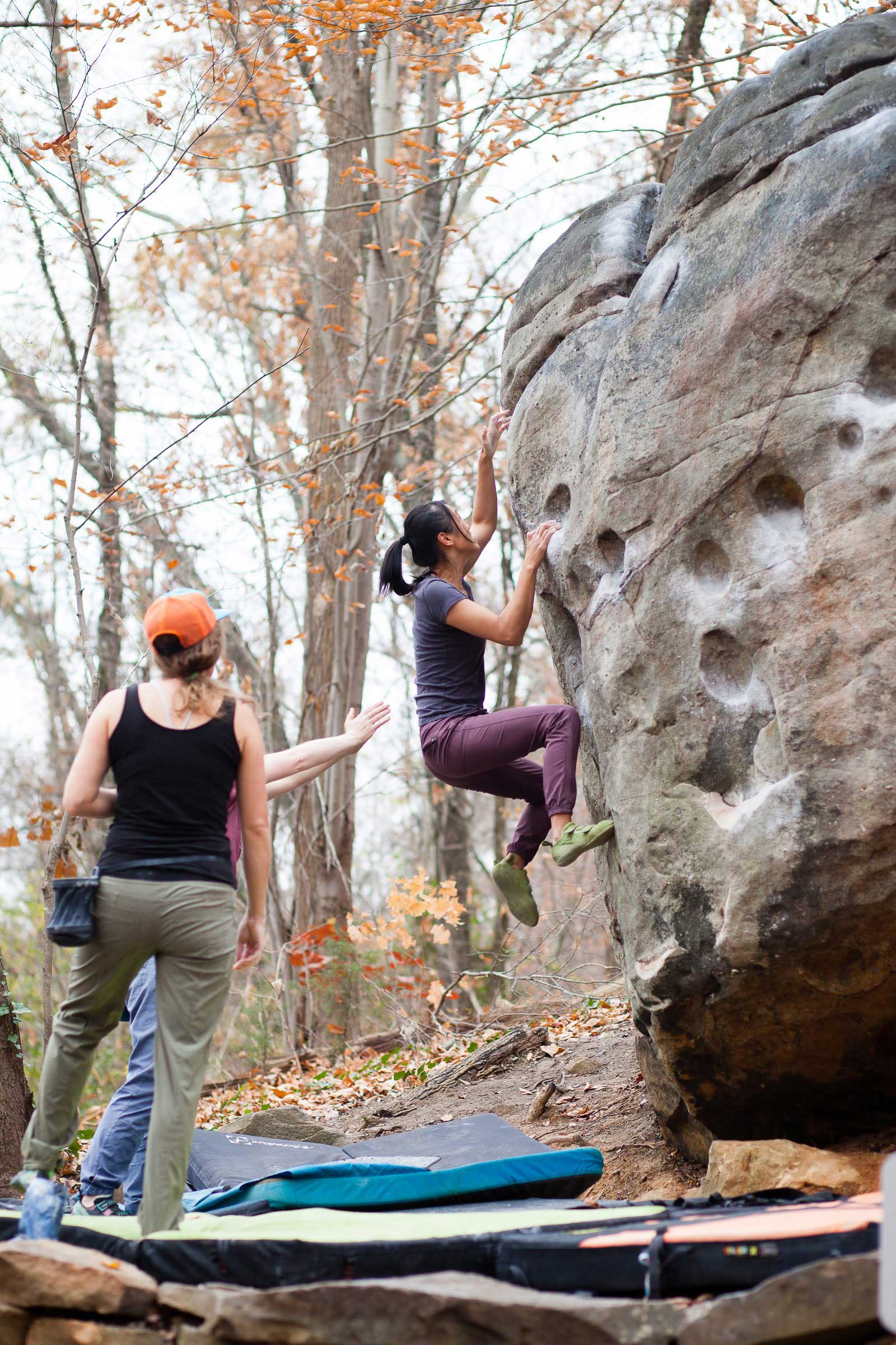 Lady climbing with spotters