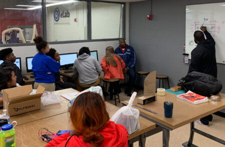 Interns Learning in the Volkswagen eLab how to make the trestle plaques with the laser cutter.