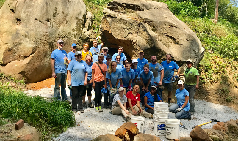 Group from Unum by the boulders they worked to create a flat landing for