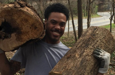 VJ holding cut logs that he is clearing from the "Far Enough" Trail