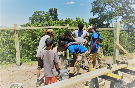 LMC Interns learning how to mix concrete for the fence posts to the garden