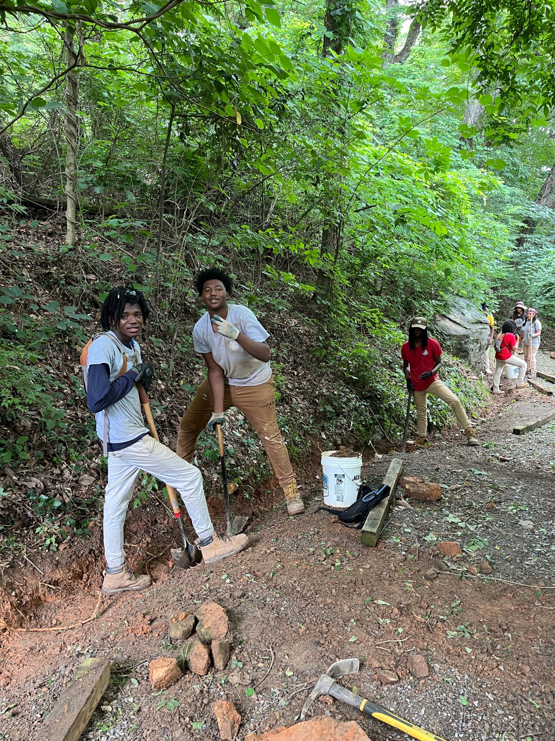 two young black males posing on a trail while working.