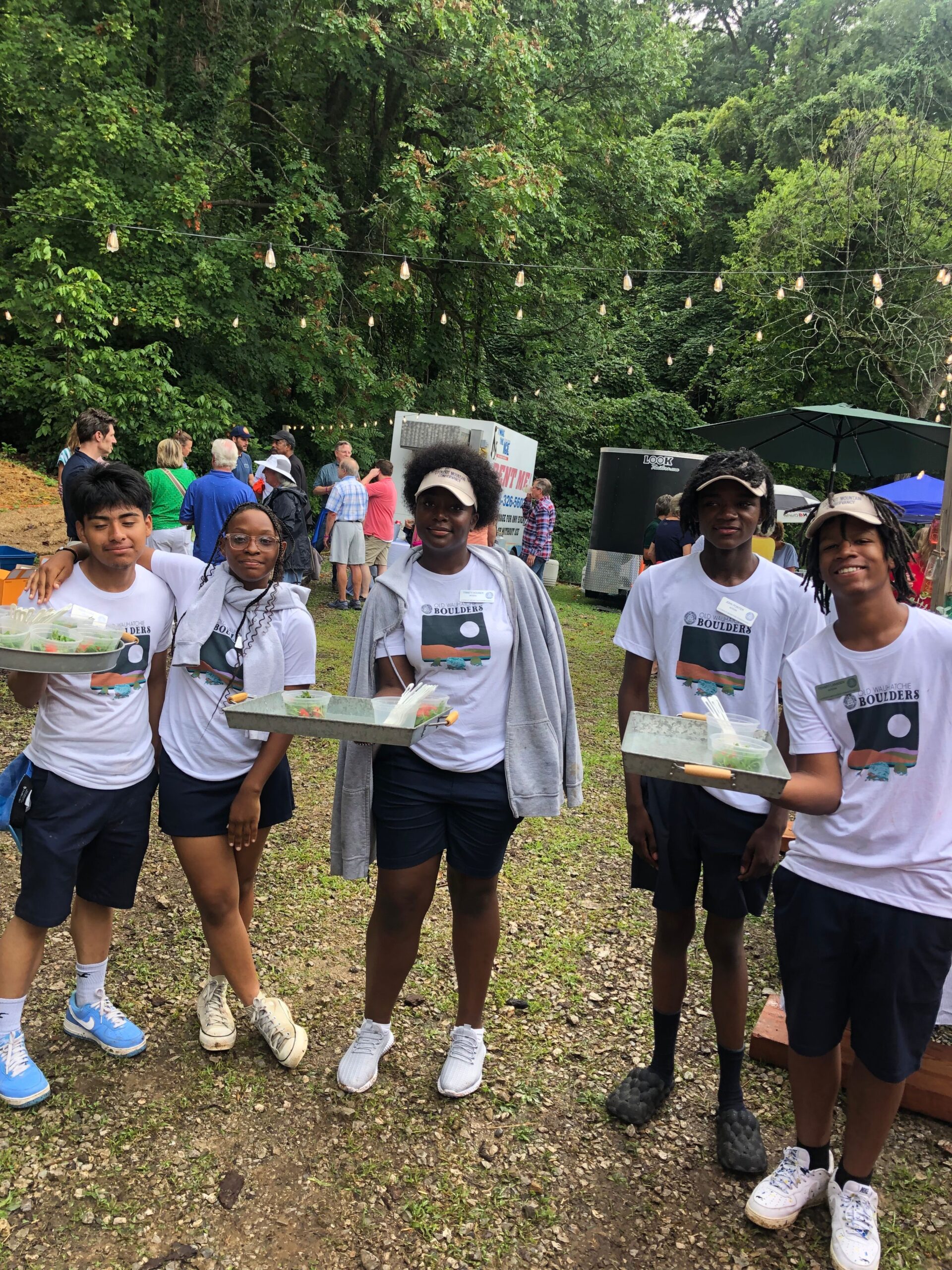 five young black teenagers pose in white shirts at annual shrimp boil.